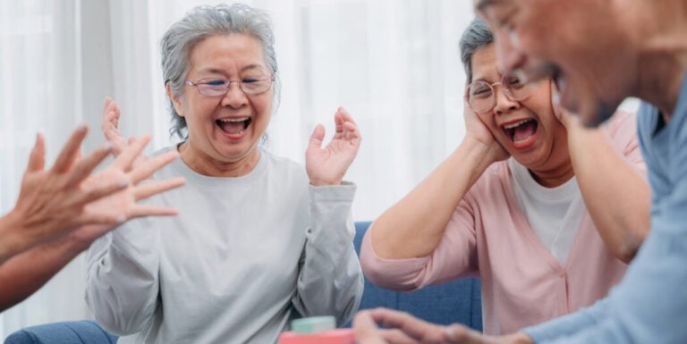 Seniors Celebrating and Laughing During Group Game at Independent Living Facility