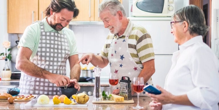 Seniors and Family Member Preparing Meals Together in a Kitchen at an Independent Living Facility